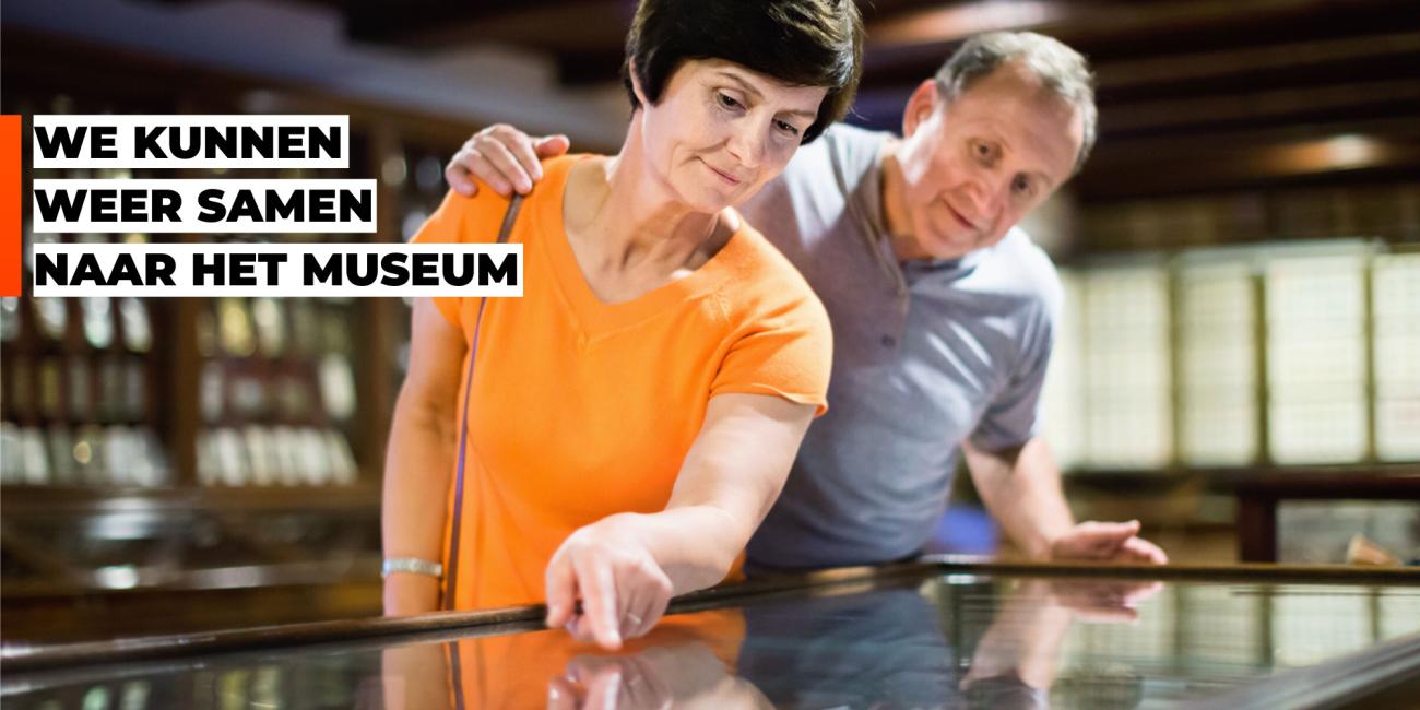 Oudere man en vrouw kijken samen naar vitrine. Citaat: We kunnen weer samen naar het museum.