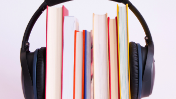 stapel boeken met daaromheen koptelefoon